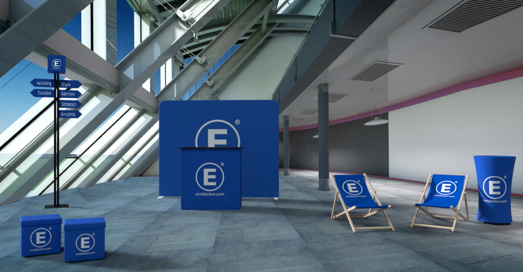 Messe Indoor Messestand mit blauer Hintergrundwand und Logo von ENTDECKER, Stühlen und Informationssäulen.