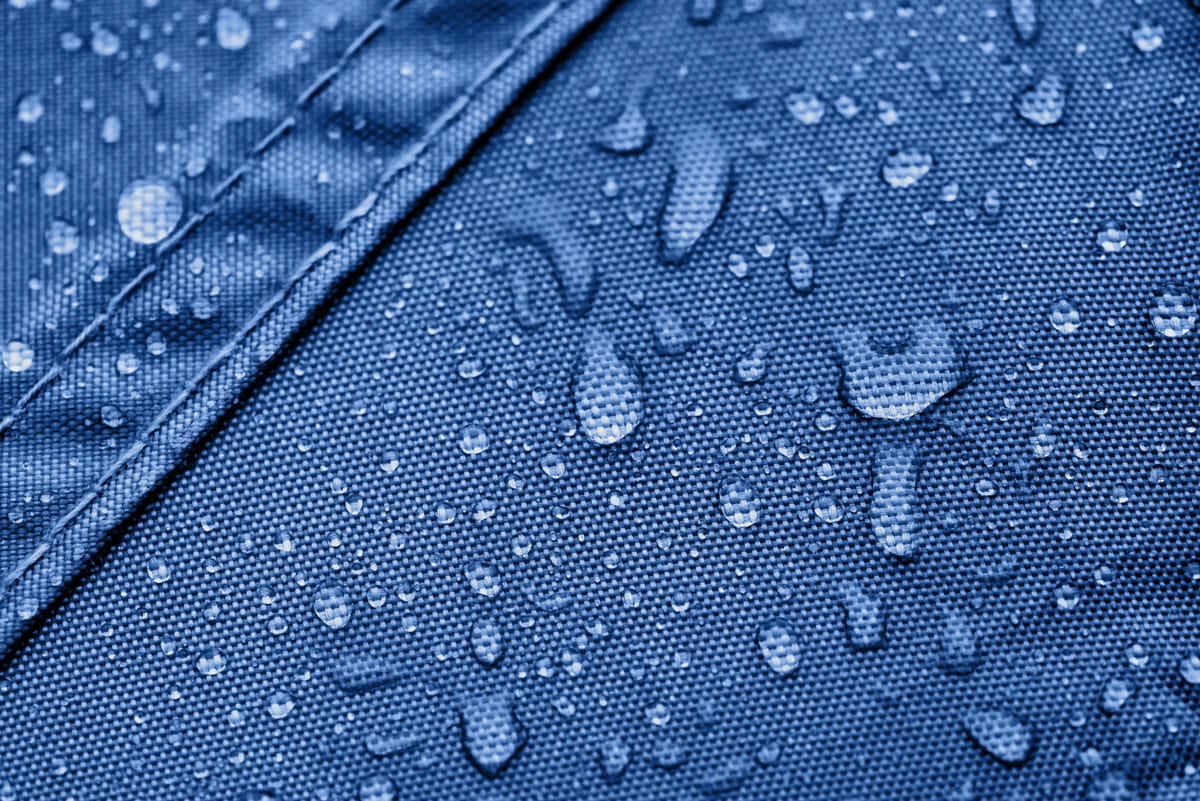 Vento Aufblasbares Zelt B1 Tropfen Zertifiziert Wasserabweisend Detailaufnahme von Wassertröpfchen auf dem blauen Material des Vento Aufblasbaren Zeltes B1, das wasserabweisend ist.