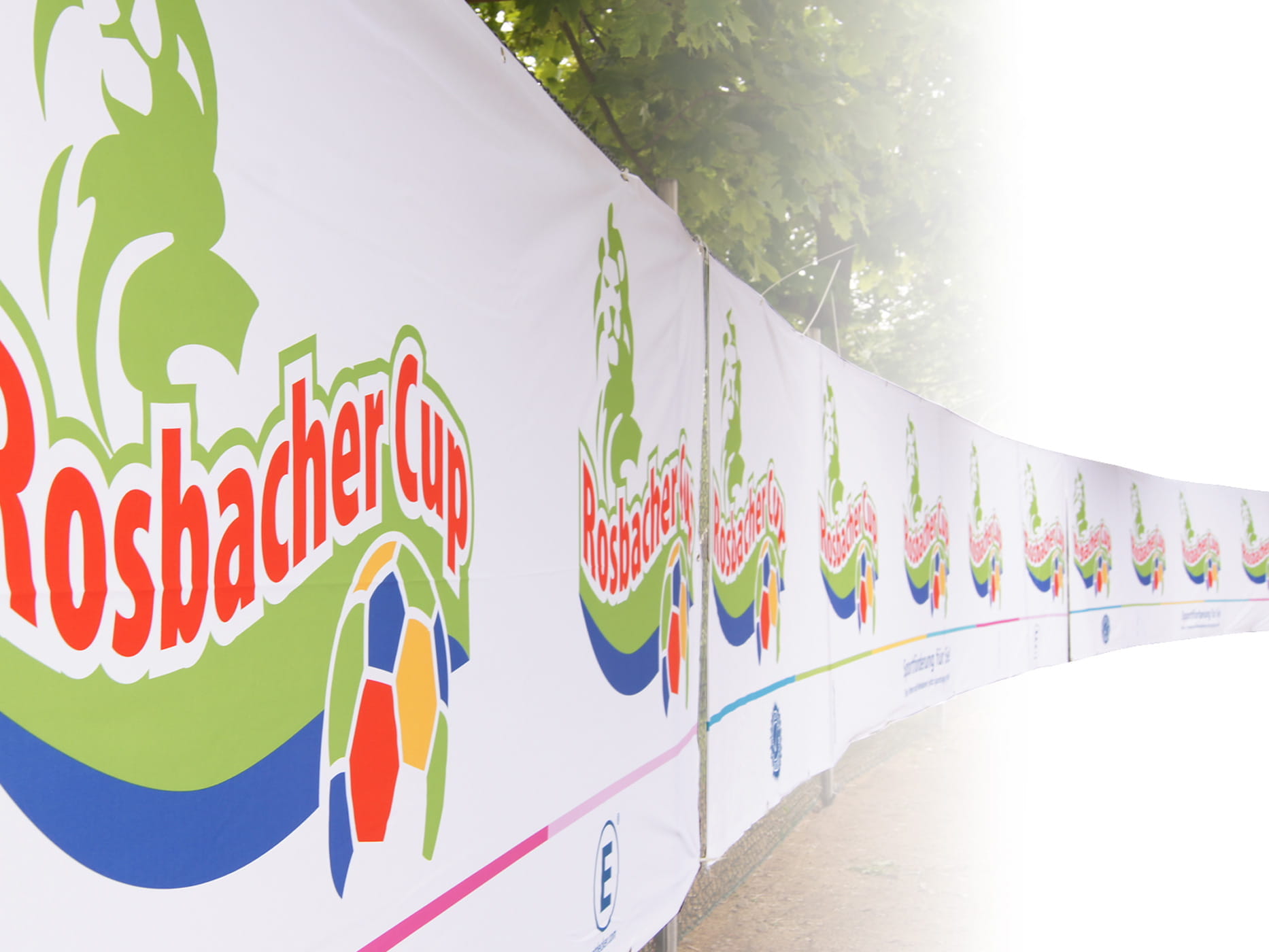 Einsatzbeispiel Werbebanner Outdoor Werbebanner für den Rosbacher Cup mit buntem Logo und Fußballmotiven.