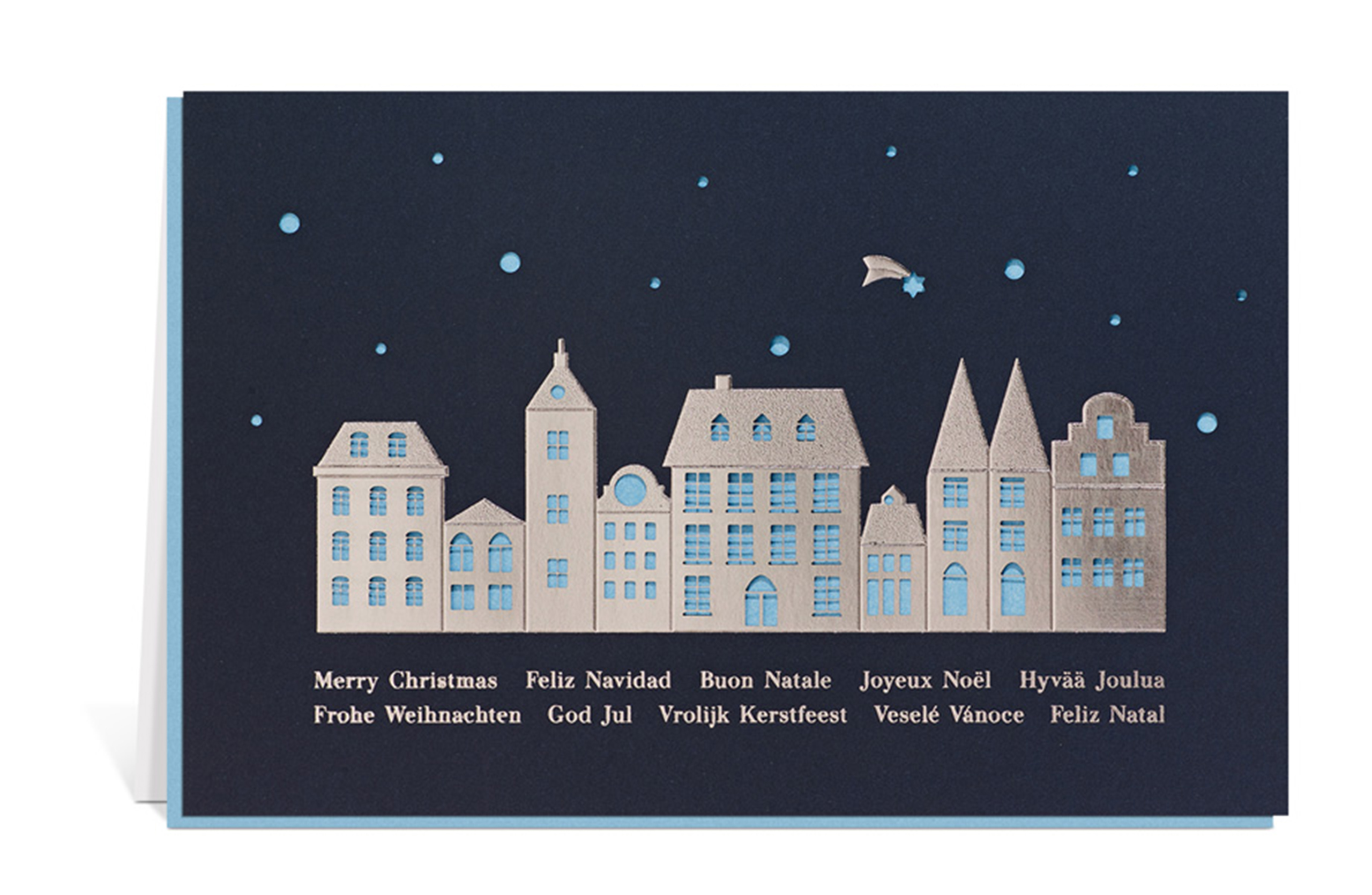 Dunkelblaue Weihnachtskarte mit silberner Silhouette von Häusern, die Fenster und die Sterne sind ausgestanzt, dahinter ein blaues Einlegeblatt. Unter den Häusern der Text: Frohe Weihnachten in verschiedenen Sprachen