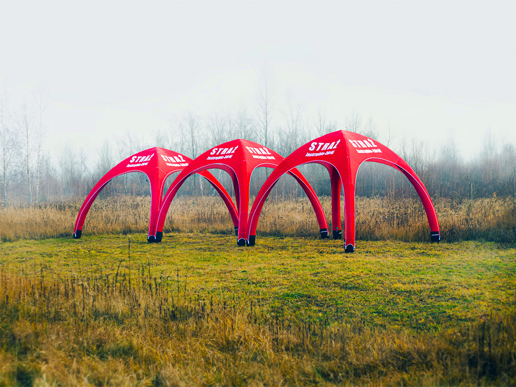rote Zelte auf einer Wiese in einer Reihe 
