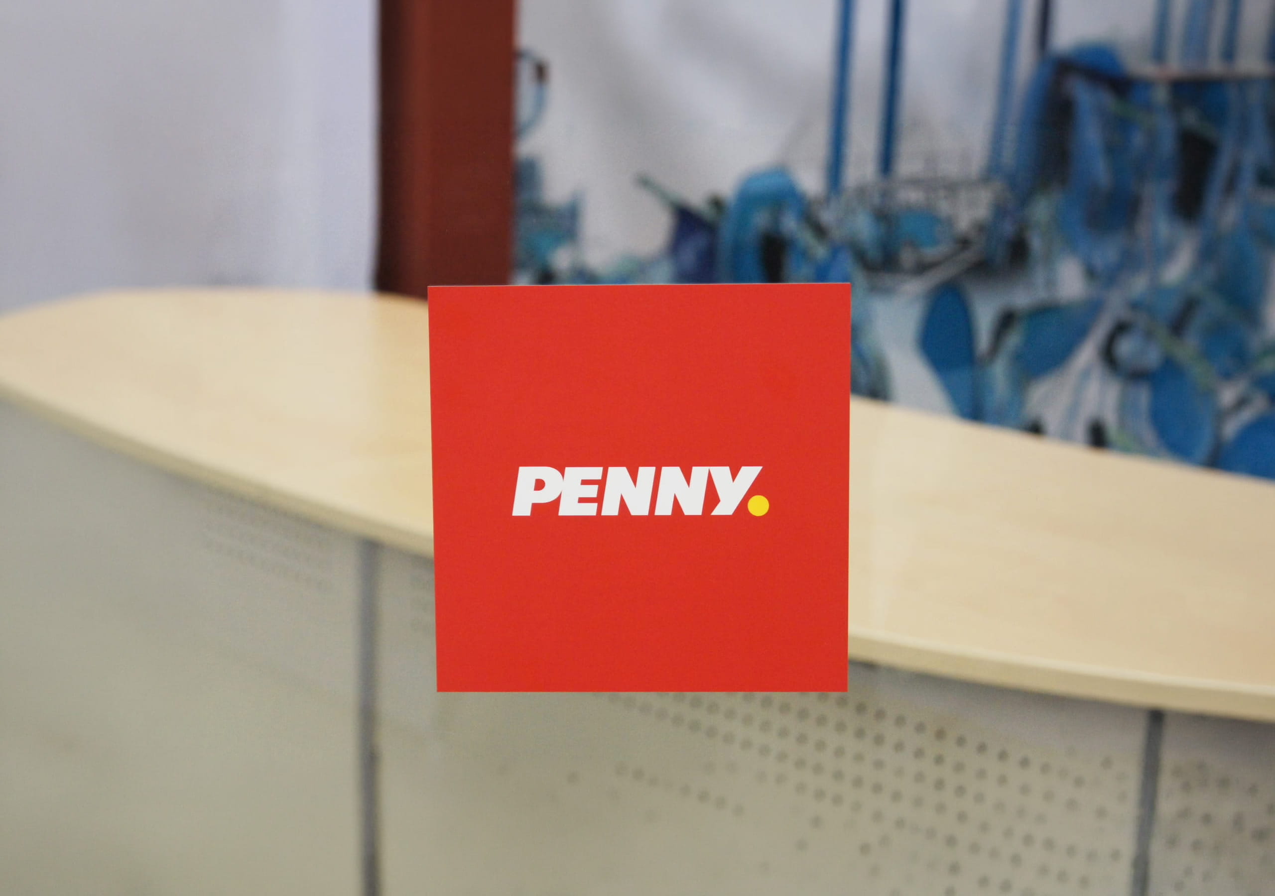 Individuell bedruckte Glasdekorfolie im Wunschformat mit PENNY-Logo auf einer Glasscheibe