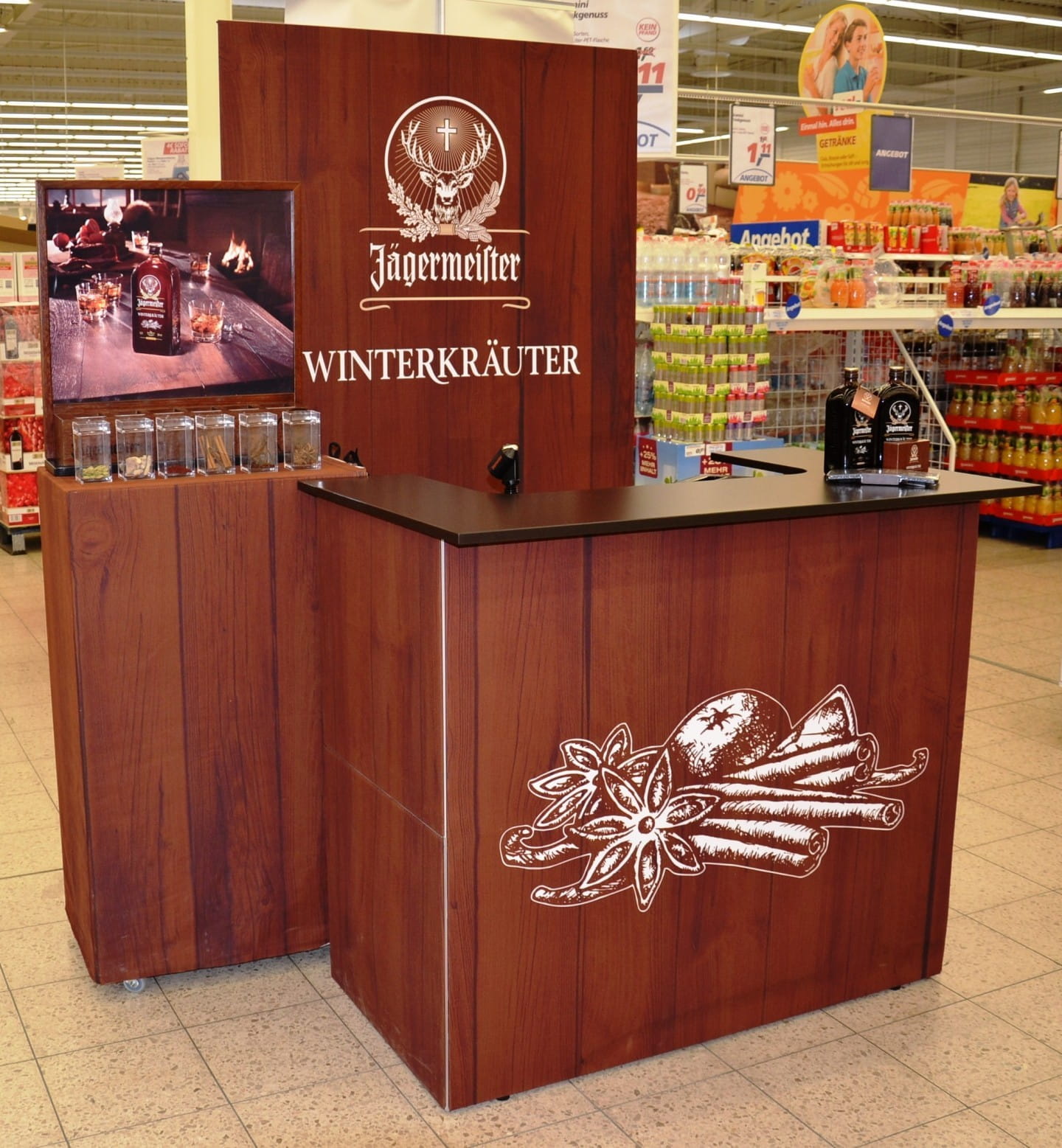 Jägermeister Messetheke Quickup Falttheke Pro Messetheke von Jägermeister mit Holzoptik, präsentiert Winterkräuter, ausgestattet mit Monitor und Produktpräsentation.