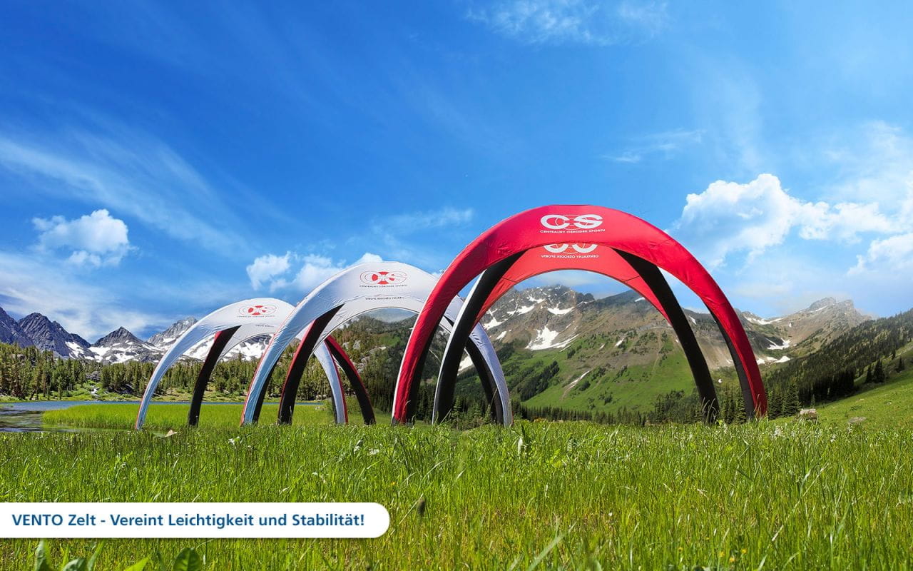 Vento Aufblasbare Zelte in der Natur Drei aufblasbare Zelte in rot und grau auf einer grünen Wiese vor einer Berglandschaft, Produkt 'Vento Aufblasbares Zelt Cos 1280X1280'.