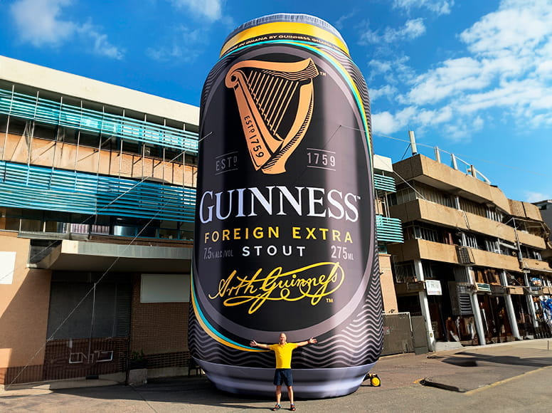 Aufblasbare Guiness-Werbung Aufblasbare Werbung in Form einer großen Guiness-Bierdose, Person steht davor.