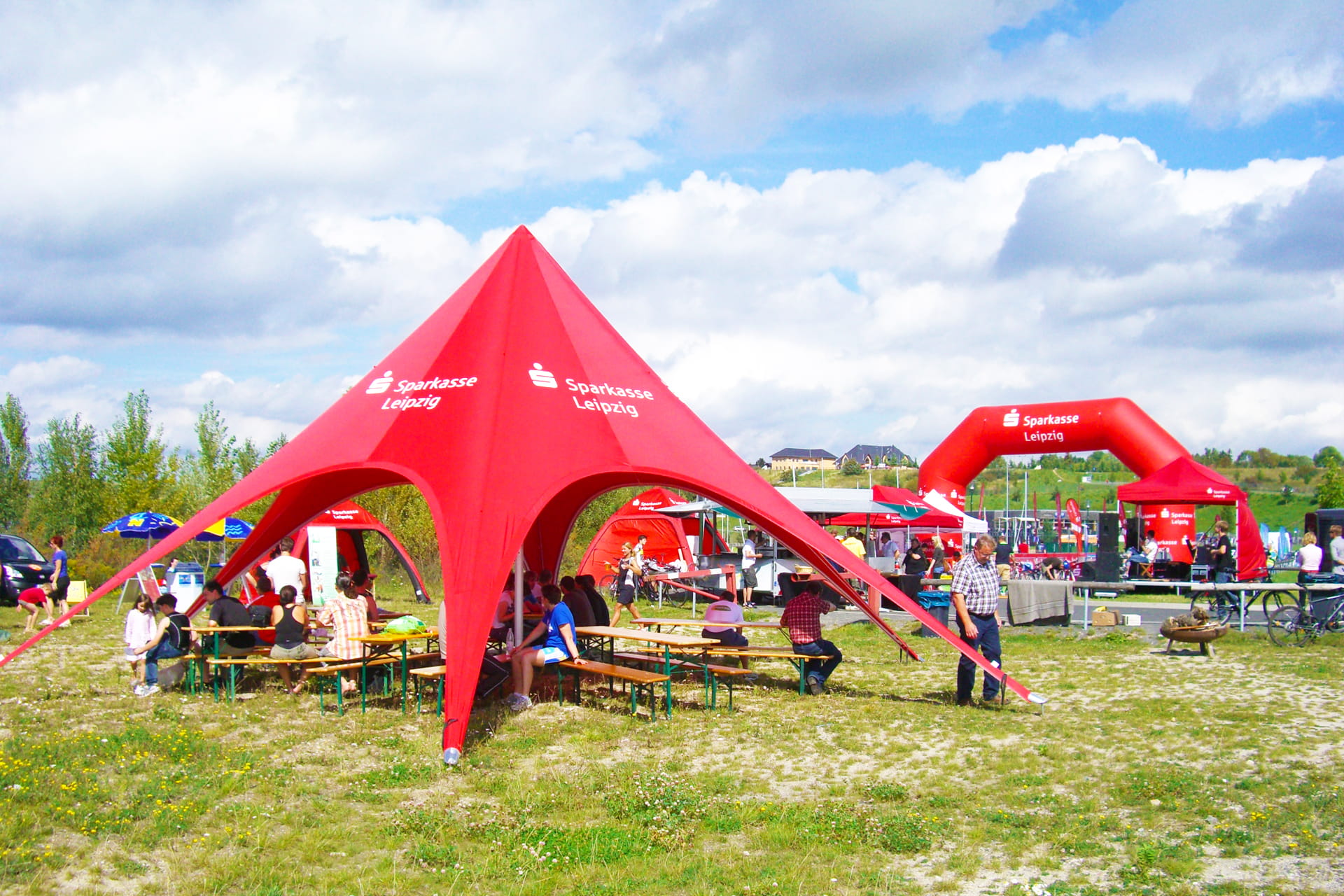 Sternenförmiges Zelt mit Label einer Bank und aufblasbarem Torbogen und Faltzelt