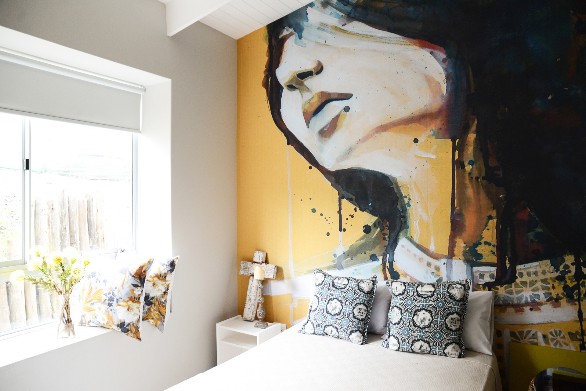 Dekoriertes Hotelzimmer mit Blick auf das Bett und dem Portrait einer Frau als Fototapete