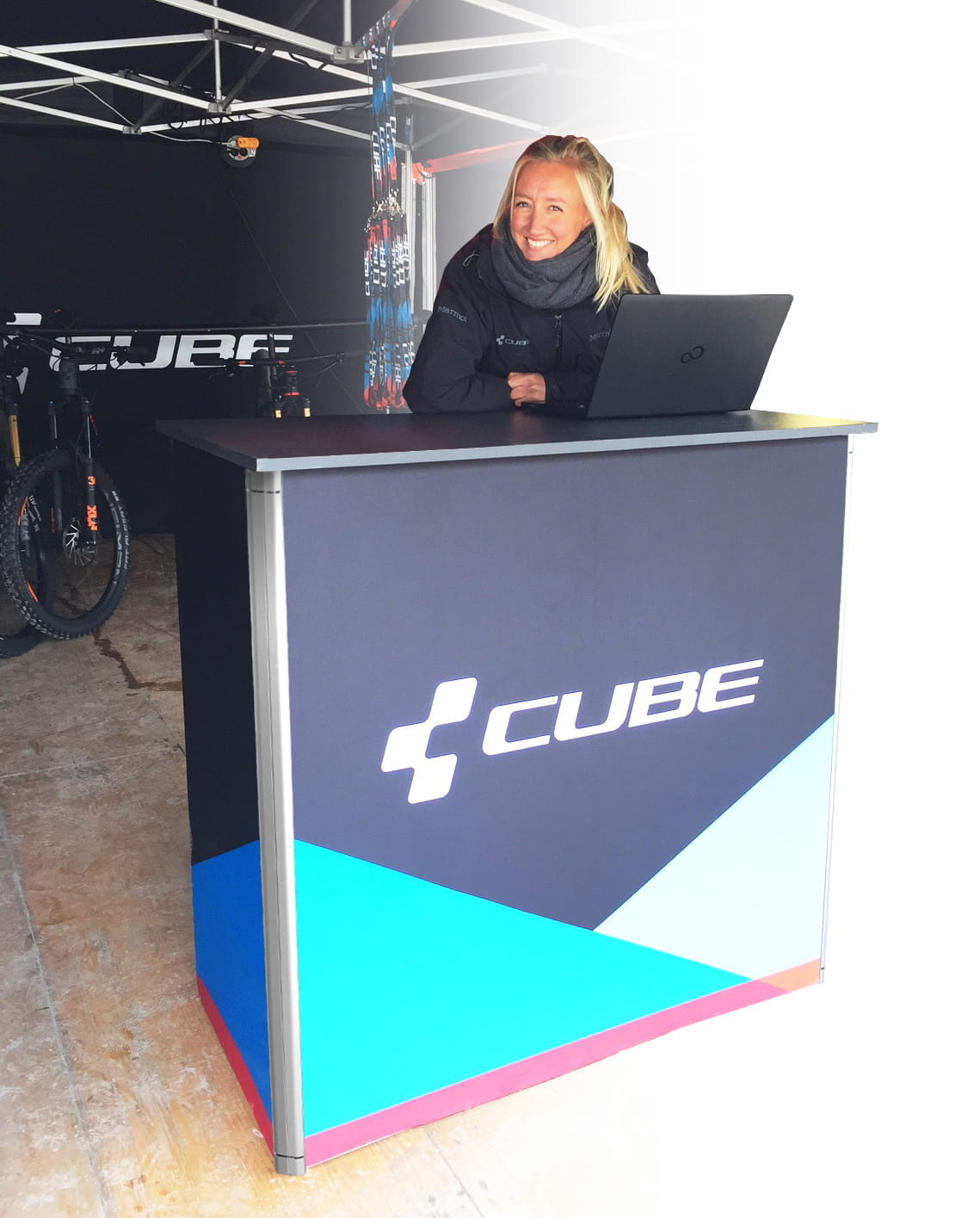Messetheke Quickup Falttheke Premium Messetheke Quickup Falttheke Premium von CUBE, besetzt von einer Person mit Laptop.