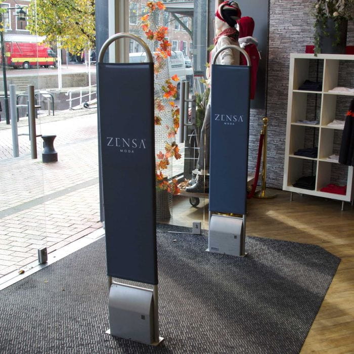 Warensicherungshussen Laden Warensicherungshussen von ZENSA MODA in einem Laden, zwei Sicherheitsständer stehen im Eingangsbereich.