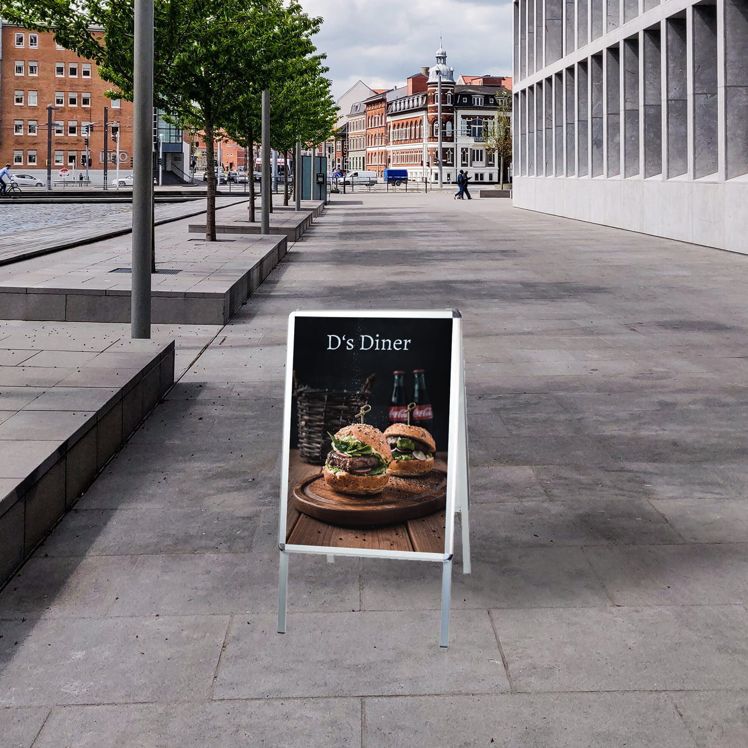 Kundenstopper Einsatzbeispiel Kundenstopper mit der Aufschrift 'D's Diner' und Bildern von Hamburgern auf einem Gehweg in einer städtischen Umgebung.