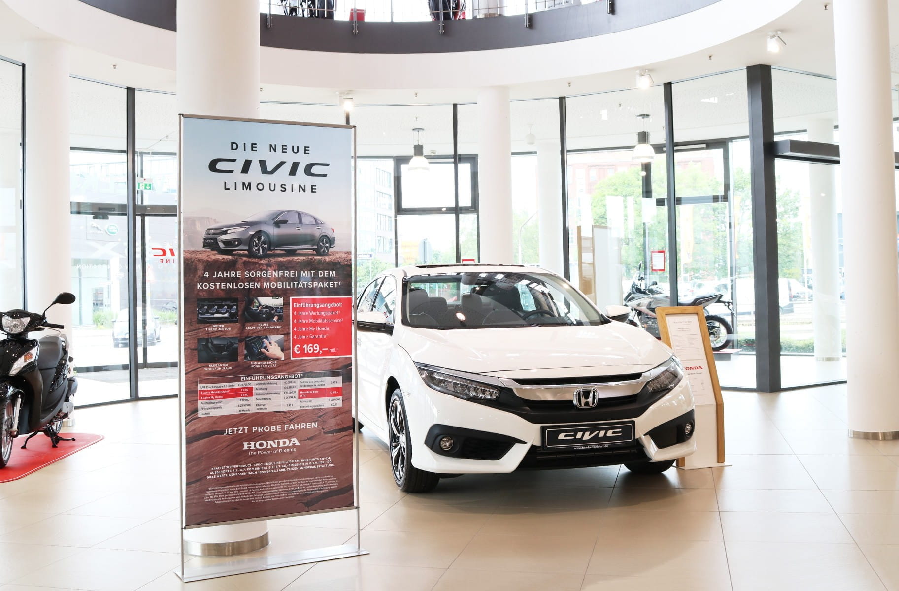 Einsatzbeispiel Roll Up Easymag Stand Honda Roll-Up Easymag Stand von Honda mit Werbung für die neue Civic Limousine im Autohaus.