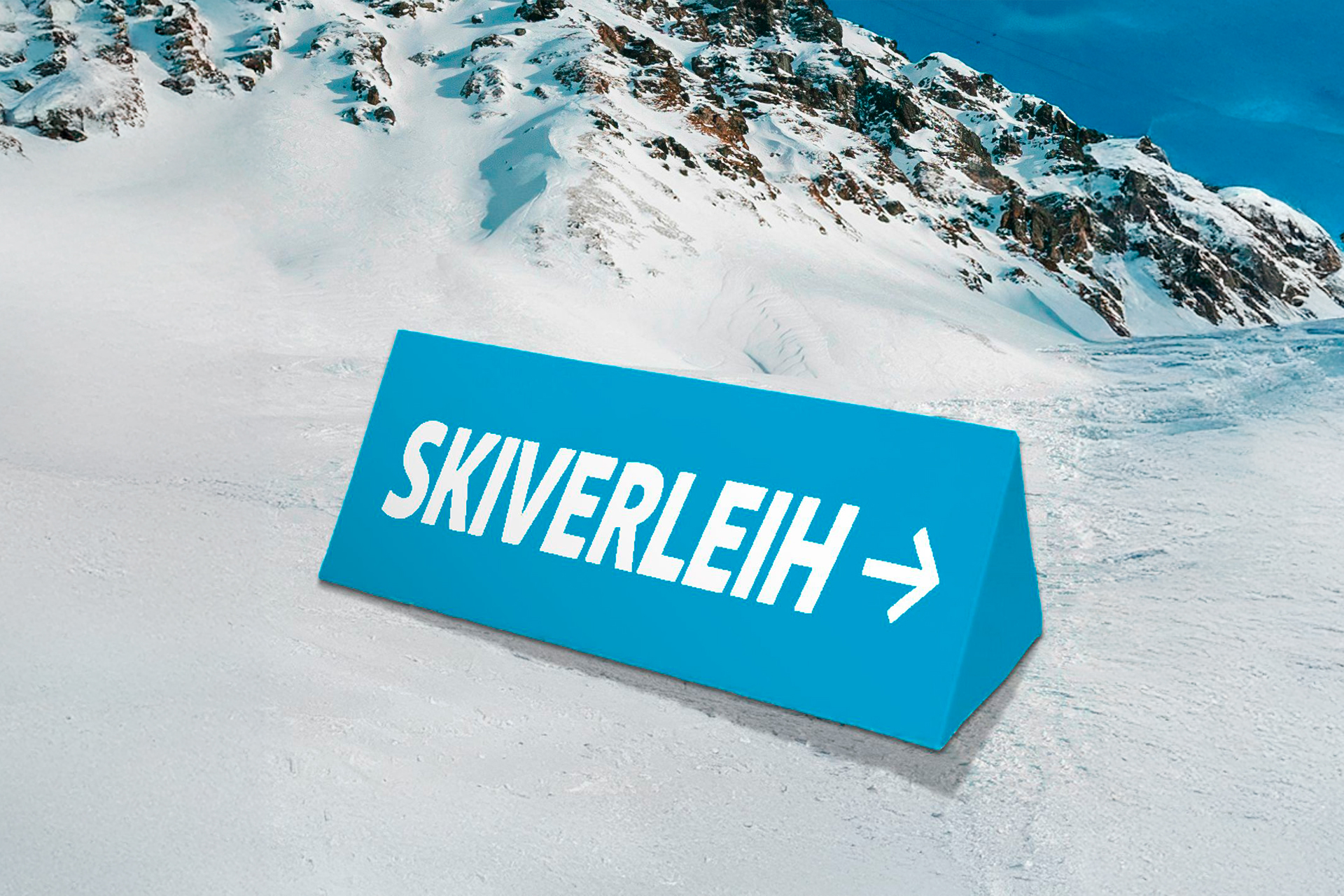Eine blaue Softbande mit dem Aufdruck "Skiverleih" im Schnee