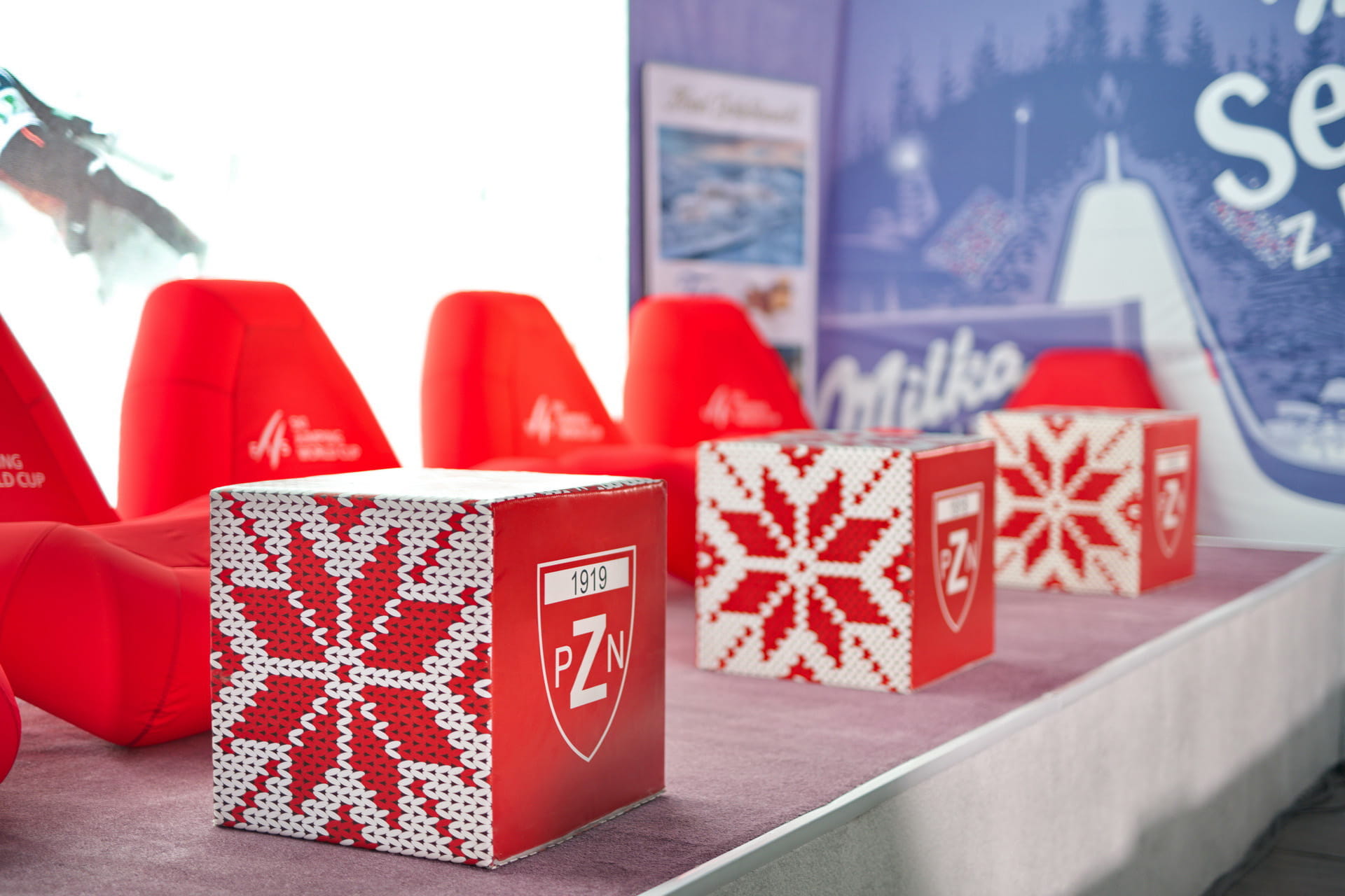 Vento Stuhl Mitko Würfel Rote Mitko-Würfel-Stühle und dekorative Würfel mit PZN-Logo auf einem Event.