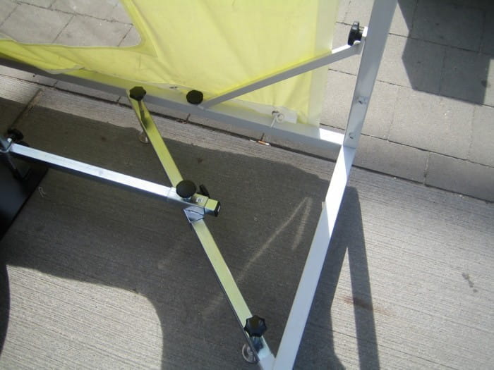 Untere Ecke Autotasche Untere Ecke Autotasche von ENTDECKER, zeigt die Struktur mit gelben und silbernen Stangen und Verbindungselementen.