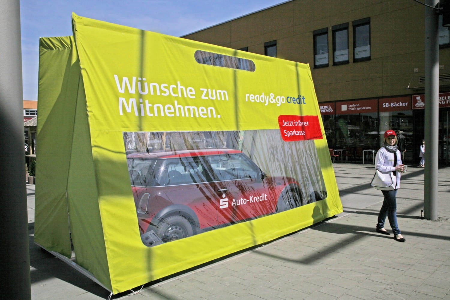Sonderprojekt Autotasche Werbung für das Sonderprojekt Autotasche mit einem Auto und dem Slogan 'Wünsche zum Mitnehmen' in einer Stadtumgebung.