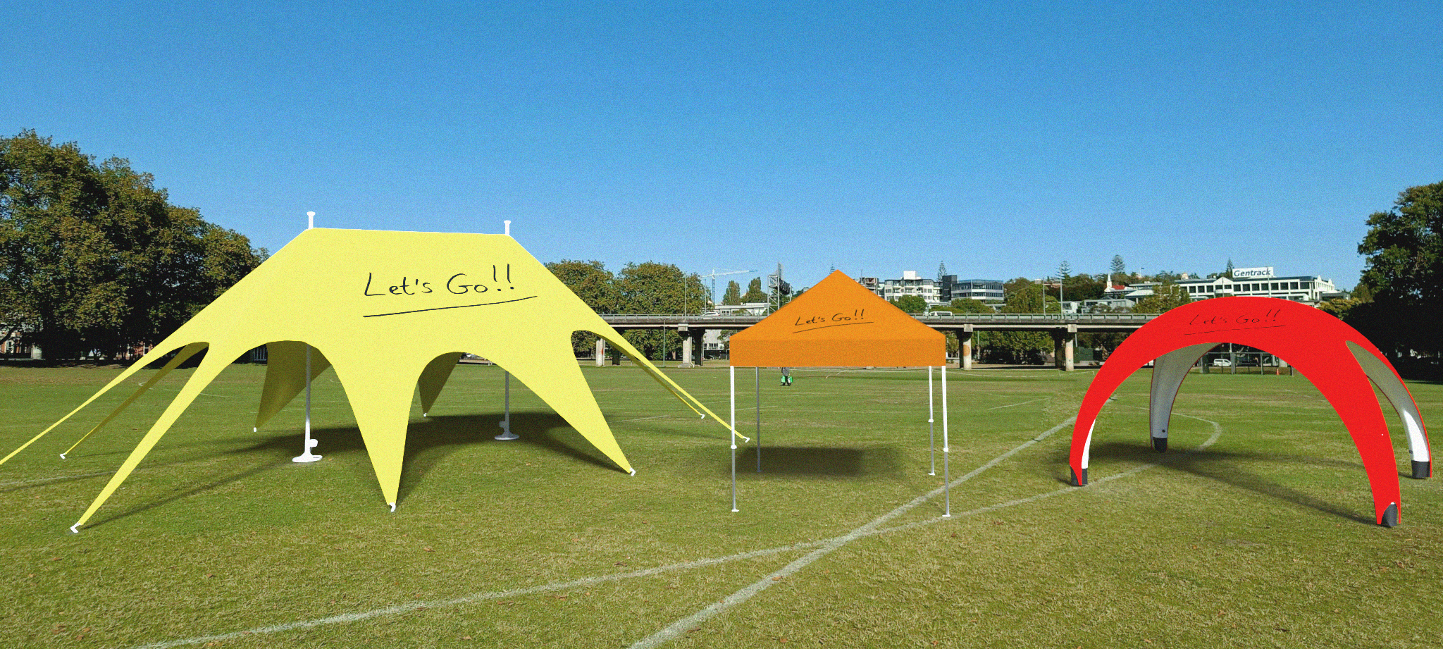 Bedruckte Zelte in drei verschiedenen Farben und Formen stehen nebeneinander auf einem Fußballfeld