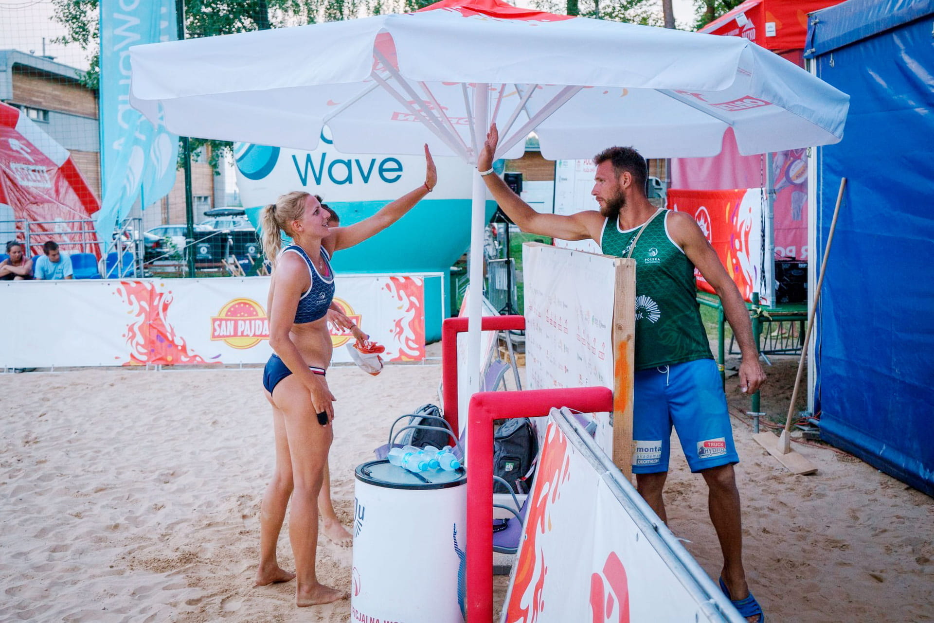 Sonnenschirm bedruckt Profi Gastronomie Large Blaue Sonnenschirme im Biergarten mit roten Blumen und Holztischen.
