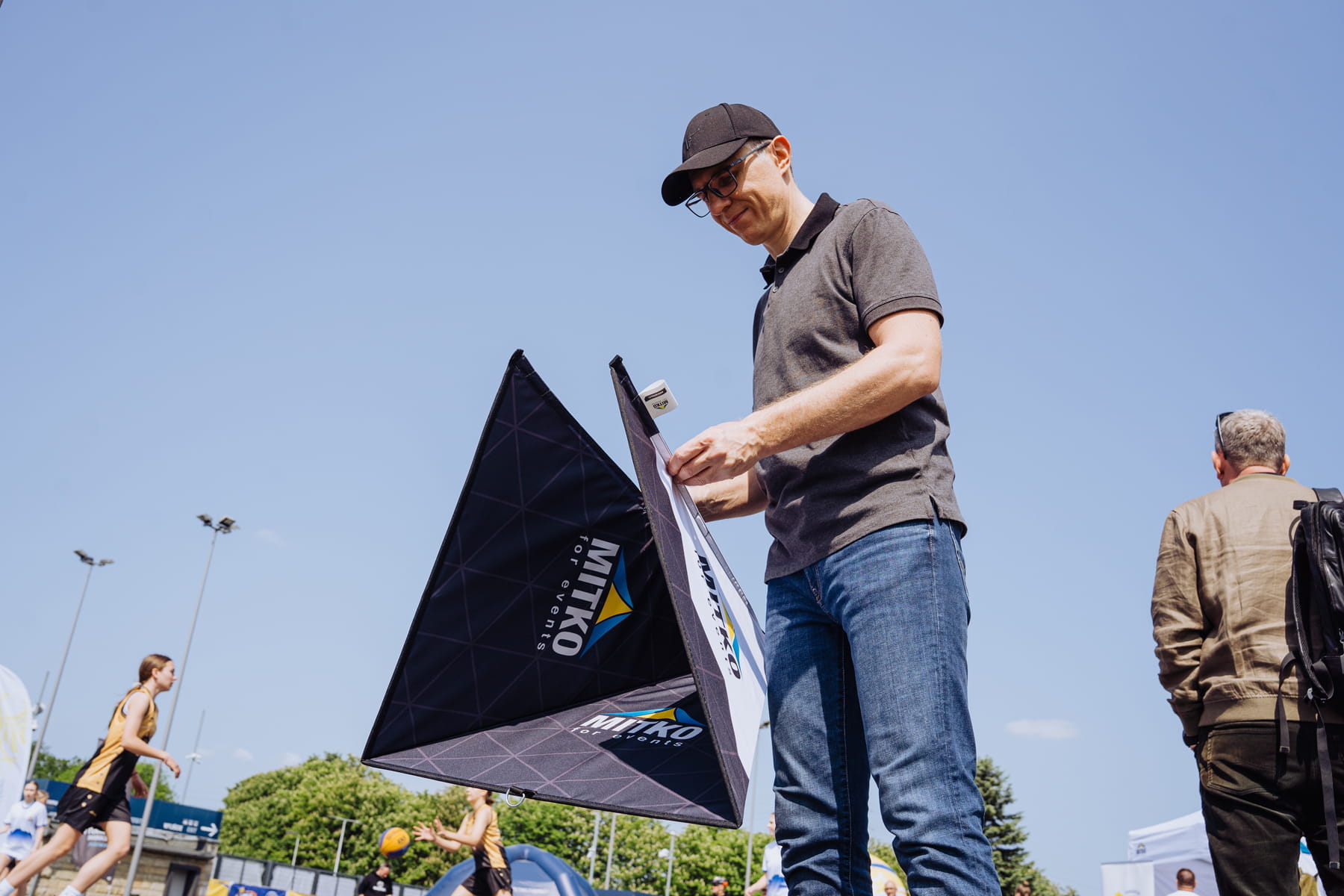 Faltbarer Aufsteller Pyramide zusammengeklappt Faltbarer Aufsteller Pyramide in zusammengeklapptem Zustand, dreieckige Form, weiße Oberfläche mit schwarzem Rand.