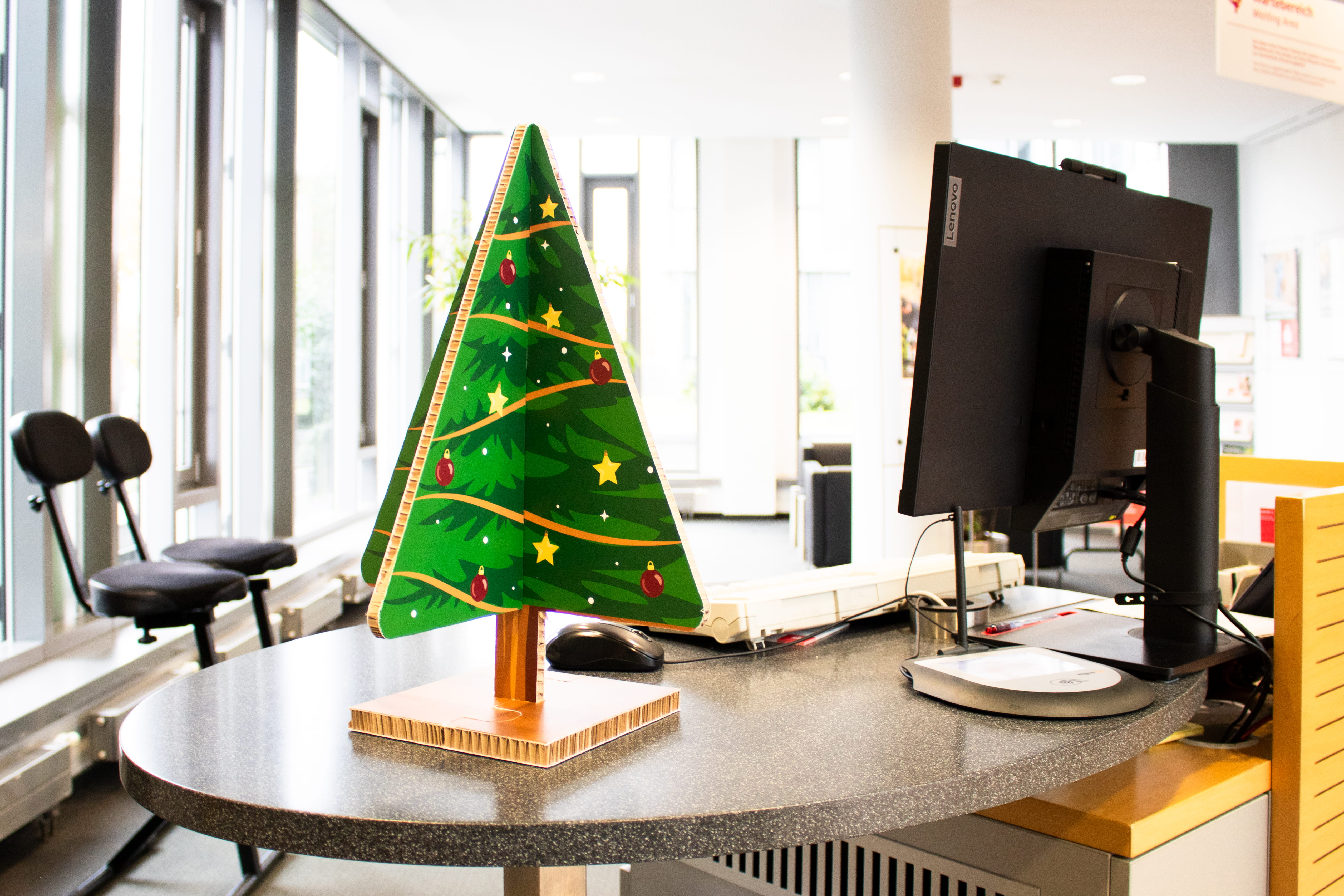Give-Away-Weihnachtsbaum Zusammensteckbarer Weihnachtsbaum aus Wabenkarton auf einem Schreibtisch im Büro