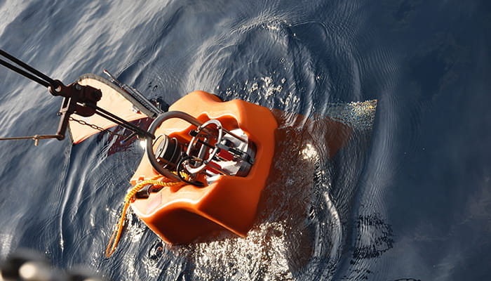 Kum Einsatz Kum Einsatz, ein orangefarbenes Unterwassergerät, das im Wasser schwimmt, mit einem Haltegriff und technischen Komponenten.
