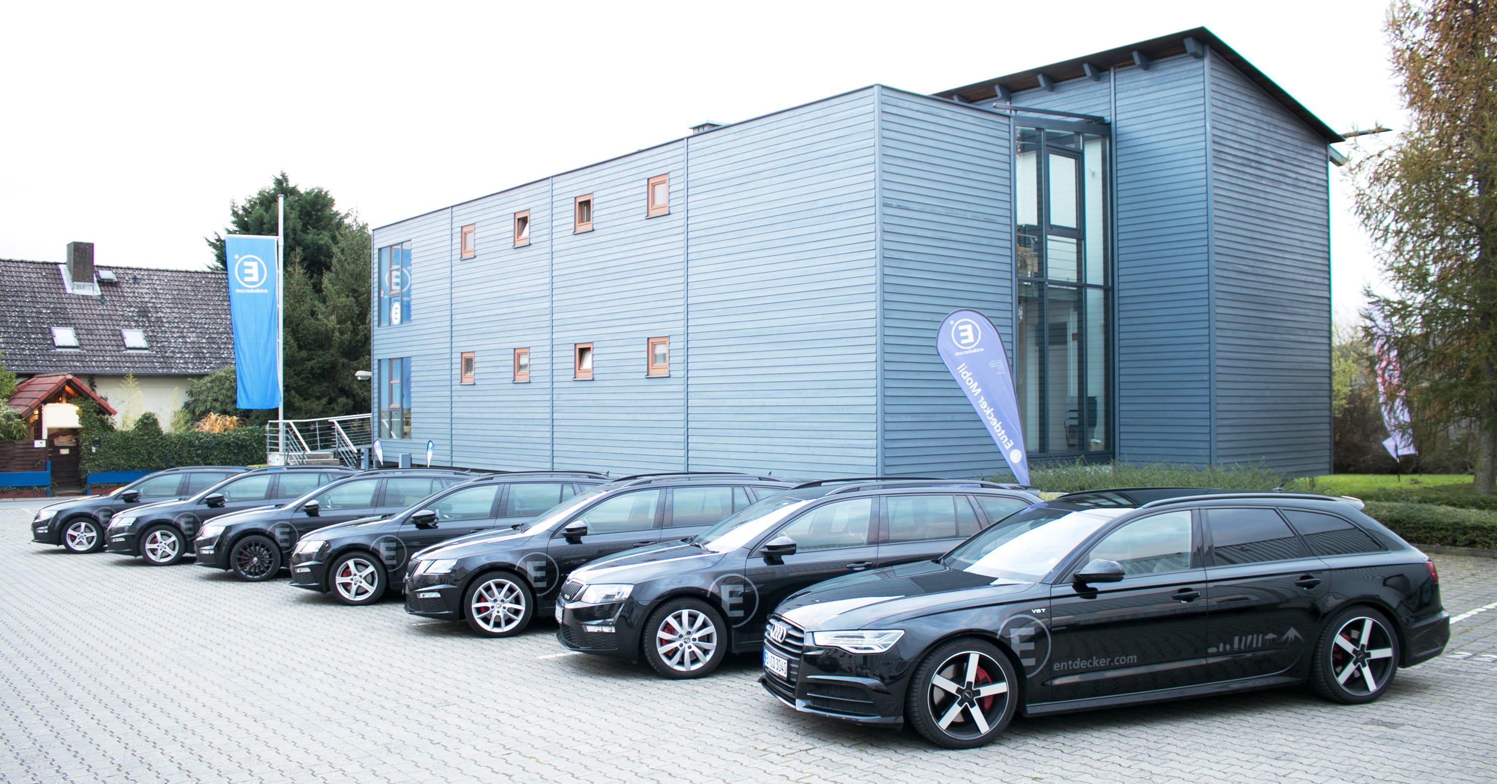 Entdecker GmbH in Rosbach Flotte von schwarzen Fahrzeugen vor dem Gebäude der Entdecker GmbH in Rosbach.