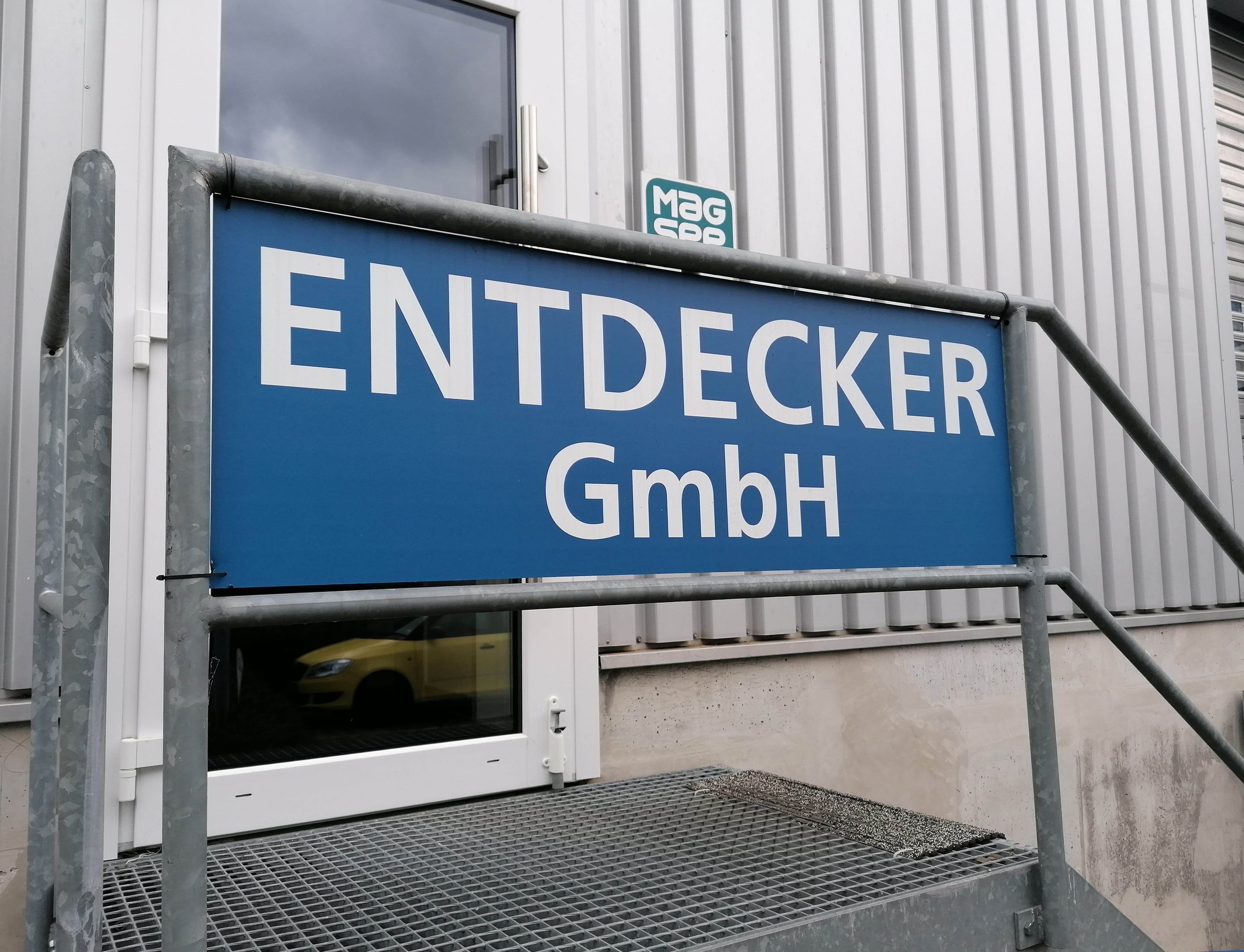Dibond Eingangsschild Entdecker GmbH Eingangsschild der Entdecker GmbH mit blauem Hintergrund und weißer Schrift.