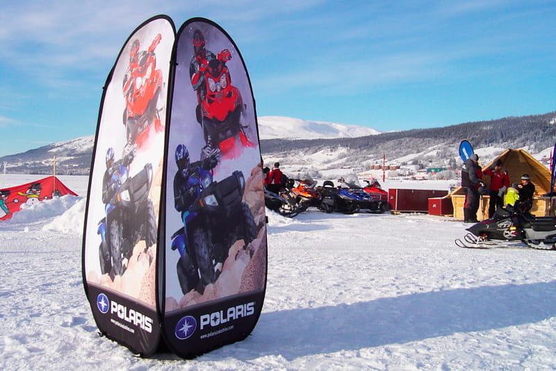 Werbezelt für Quicktower Winter von Polaris Zelt mit Werbung für den Produkt 'Quicktower Winter' von Polaris, umgeben von Schneemobilen auf einer verschneiten Landschaft.