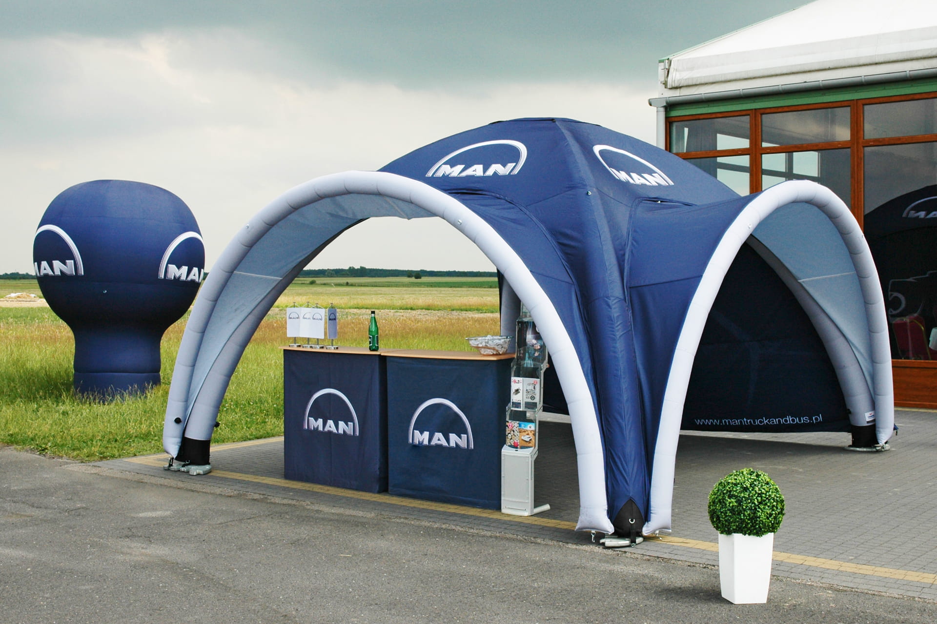 Outdoor-Info Stand mit einem aufblasbaren Zelt, Theken und einer aufblasbaren Logofigur für MAN-Trucks