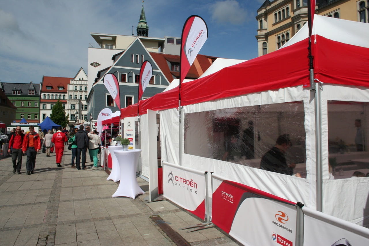 Zeltstadt Eventzelt Easydome xp Zeltstadt Eventzelt Easydome Xp mit roten und weißen Markisen, beschriftet mit Citroën und anderen Logos, auf einem Platz mit Besuchern.