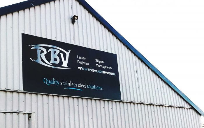 Werbeschild Wand Werbeschild für RBY mit dem Slogan 'Quality stainless steel solutions' an einer Wand.