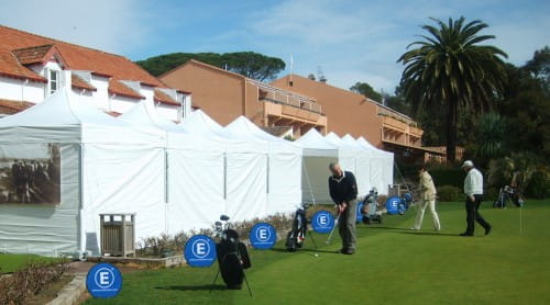 Werbebande Easy Disc Flex Bodenmontage Werbedisplay Easydisc Flex in Bodenmontage auf einem Golfplatz mit Golfern und Zelten im Hintergrund.