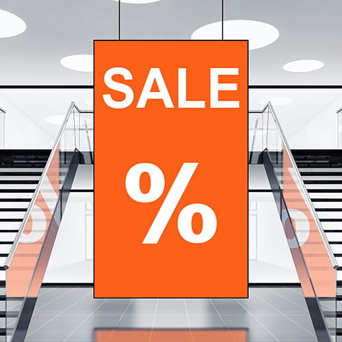 Deckenhänger Schild Einkaufszentrum Deckenhänger Schild mit dem Text 'SALE' und Prozentzeichen, aufgehängt in einem Einkaufszentrum.