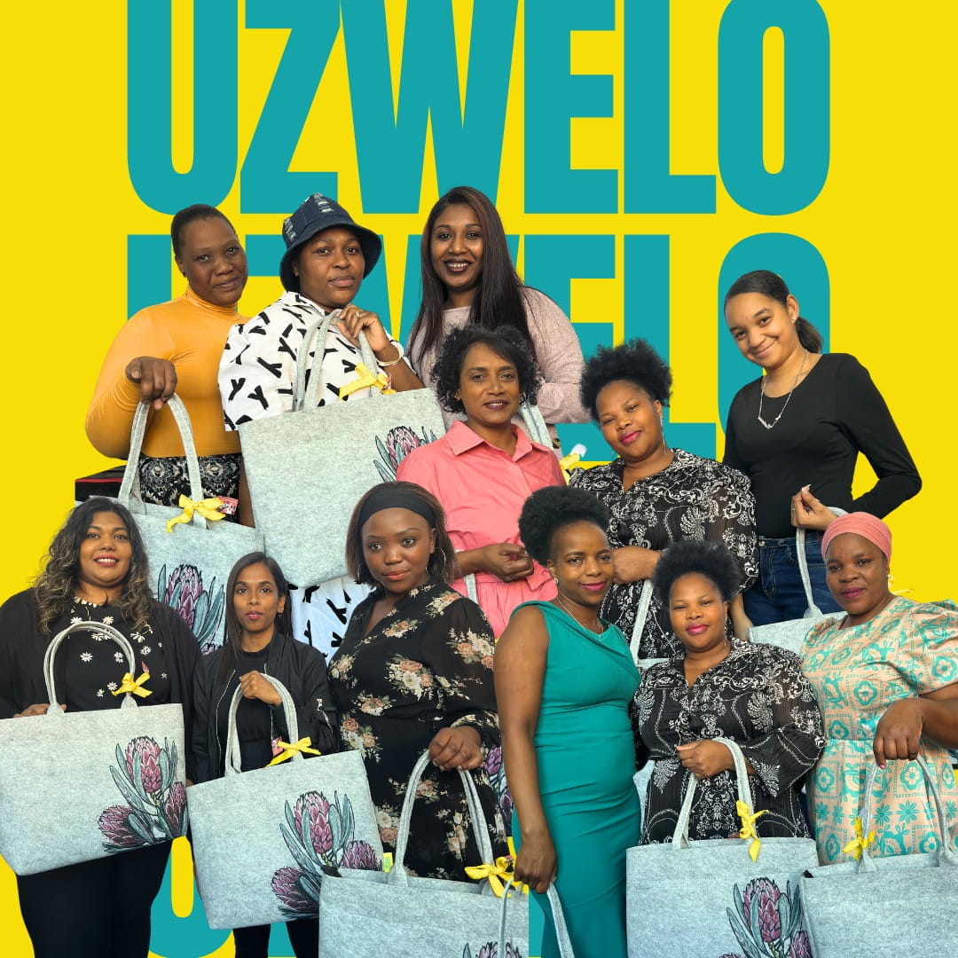 Frauen mit Taschen vor 'UZWELO'-Hintergrund Gruppe von Frauen mit Taschen, die mit gelben Schleifen verziert sind, vor einem gelben Hintergrund mit dem Text 'UZWELO'.