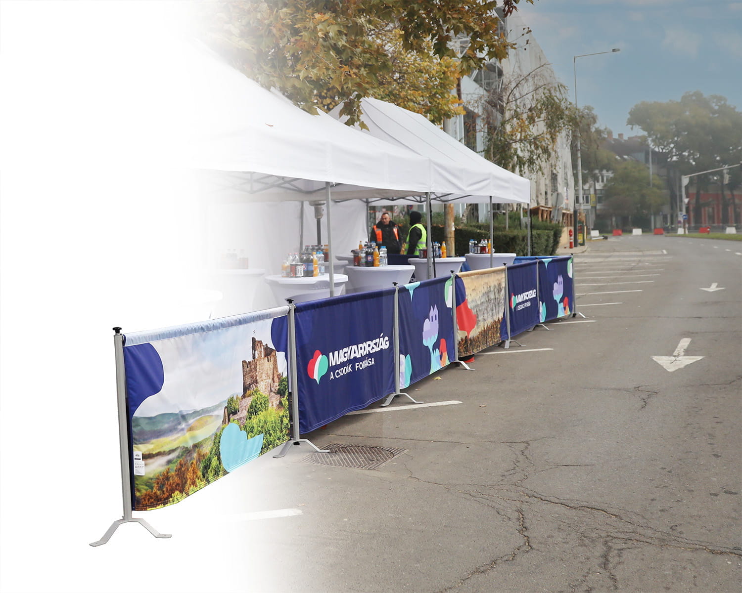 Rennsportbande in Reihe Rennsportbande in Reihe mit bunten Grafiken, auf einer Straße aufgestellt, um einen Eventbereich abzugrenzen.