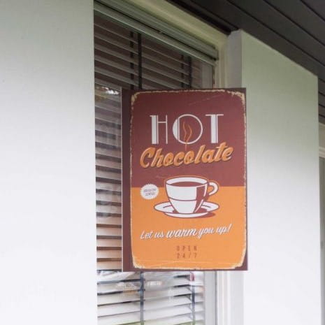 Maklerschild Cafe Maklerschild für ein Café mit der Aufschrift 'HOT Chocolate' und dem Slogan 'Let us warm you up!'