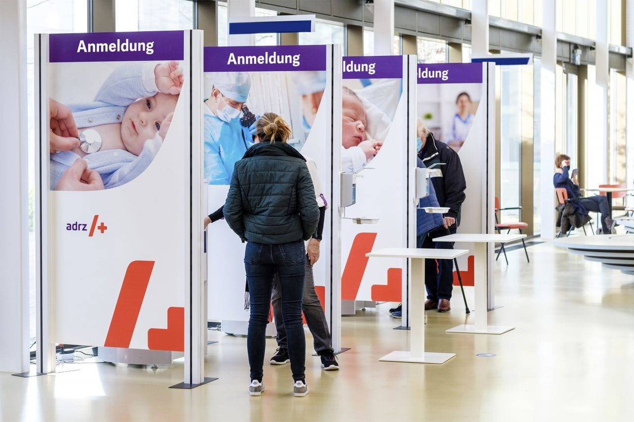 Inhaker Raumteiler Raumteiler mit Anmeldeständen bei einer Veranstaltung, Personen stehen in Warteschlange.