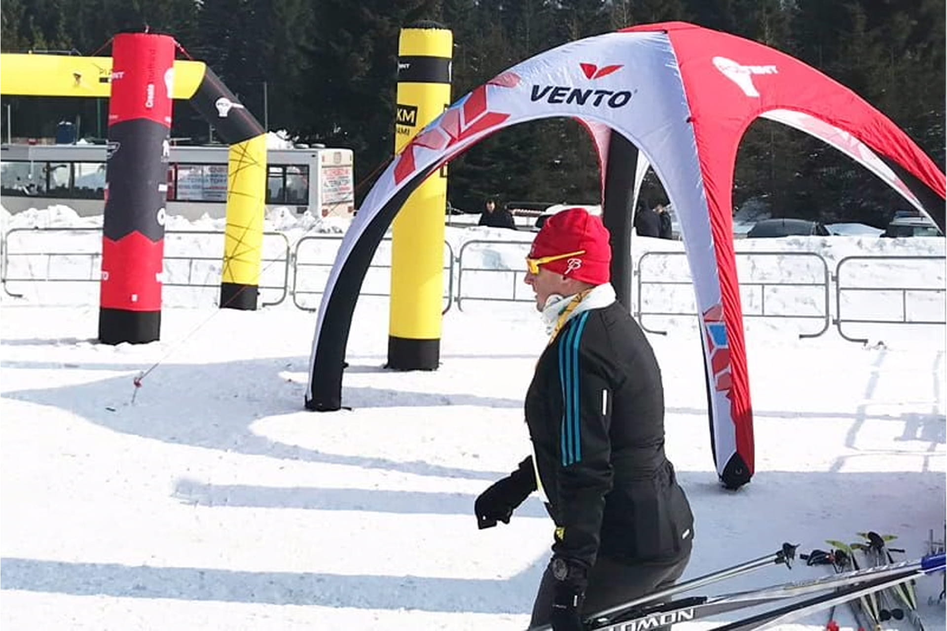 Sportler läuft durch den Schnee vorbei an verschiedenen aufblasbaren, bedruckten Werbeträgern