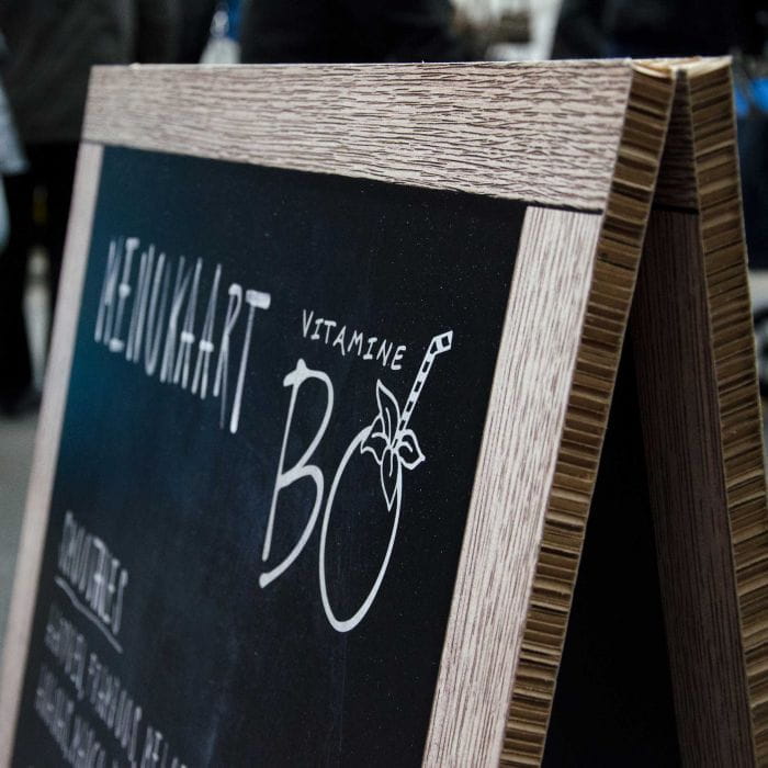 Reboard Speisekarte Reboard Speisekarte mit der Aufschrift 'HEIMAT' und 'VITAMINE BO', auf einem Holzständer.