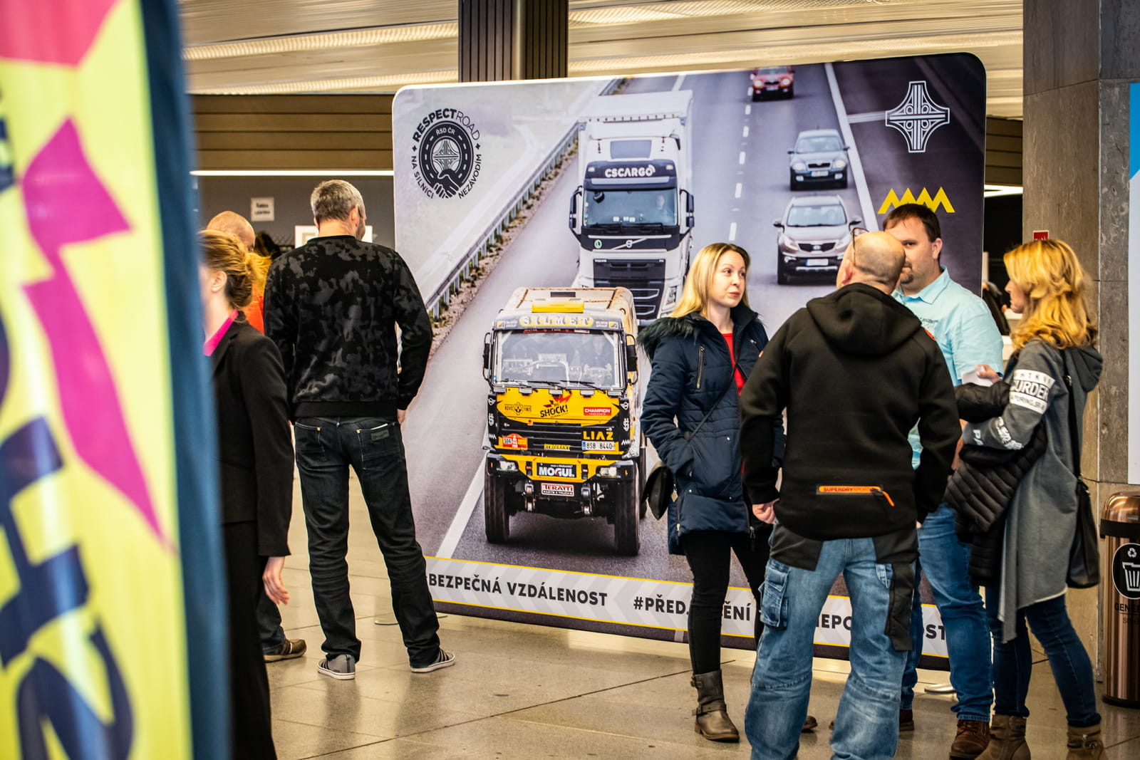 Zipper Wall auf Messe Messestand mit dem Produkt 'Zipper Wall', Personen stehen vor einem großen Banner mit einem Lkw auf einer Straße.